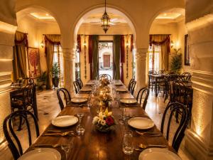 a long dining room with a long table with chairs at Pachewar Garh - A Heritage Fort in Pachhewar