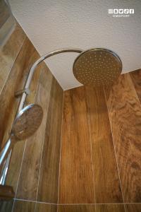 a shower head in a bathroom with a wooden floor at Dahlia suite & spa in Nîmes +8 photos