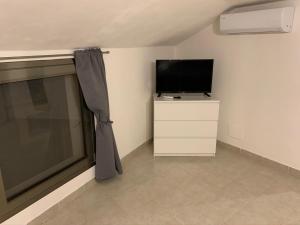 a living room with a television and a window at Casa Nerina in centro Scicli in Scicli