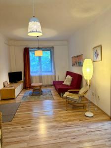 a living room with a red couch and a red chair at LaBONI Apartman in Miskolctapolca
