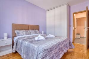 a bedroom with a large bed with towels on it at V&V apartment in Podgorica