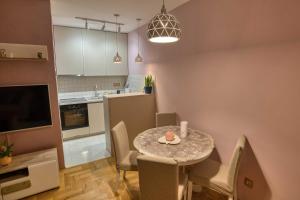a kitchen and dining room with a table and chairs at V&V apartment in Podgorica