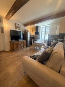 a living room with a couch and a table at Entre Pic et Rivière in Saint-Martin-de-Londres