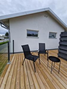 two chairs and a table on a wooden deck at Wonderfully unique accommodation in Bålsta