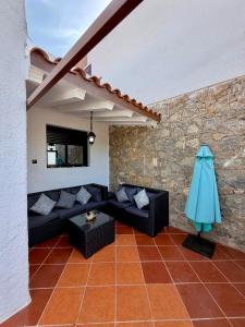 a living room with black couches and a stone wall at Résidence Mdiq marsa - maison de vacances in M'diq +15 photos