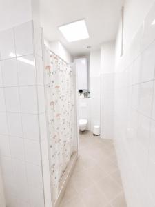 a white bathroom with a toilet and a shower stall at Konvoj szálló in Budapest +32 photos