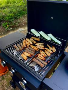 a bunch of sausages and vegetables cooking on a grill at MonteMare Holiday home in Lič