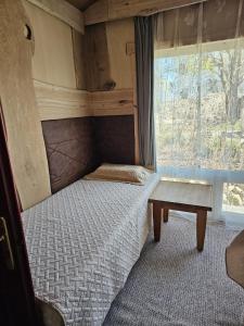 a small bed in a room with a window at Eco Retreat Saunahaus in Putgarten