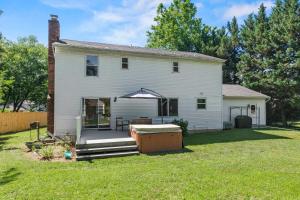 a white house with a backyard with a hot tub at Spacious Edgewater Home Deck & Sleeps 10 in Edgewater