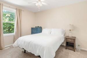 a bedroom with a white bed and a window at Spacious Edgewater Home Deck & Sleeps 10 in Edgewater