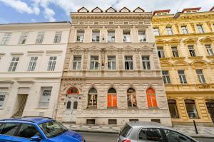 two cars parked in front of a building with orange doors at Wellness Hostel Central in Prague