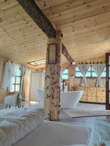a bedroom with a tub and a wooden ceiling at Lombfészek in Rezi