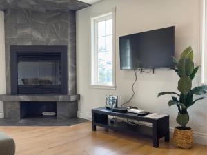 a living room with a fireplace and a tv on the wall at Hôtel Matha in Saint-Jean-de-Matha