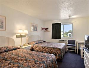 a hotel room with two beds and a television at Americas Stay Inn-Leavenworth in Leavenworth