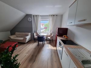 a kitchen and living room with a table and a couch at Apartma 8 in Pekre