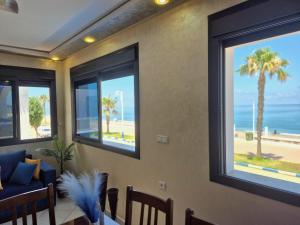 a living room with windows with a view of the beach at Beachfront First floor mekad in Oued Laou
