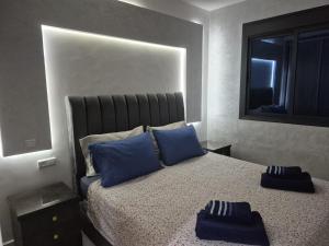 a bedroom with a bed with blue pillows and a mirror at Beachfront First floor mekad in Oued Laou