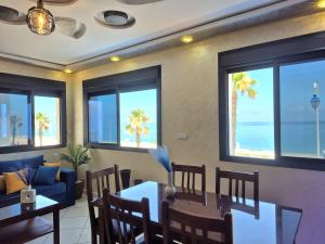 a living room with a table and chairs and the ocean at Beachfront First floor mekad in Oued Laou