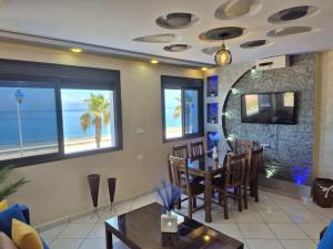 a dining room with a table and chairs and the ocean at Beachfront First floor mekad in Oued Laou