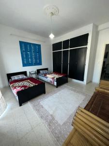 a living room with two beds and a large window at Appartement henda 01 in Sousse