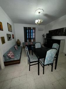 a living room with a table and chairs and a couch at Appartement henda 01 in Sousse