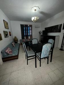 a living room with a table and chairs and a couch at Appartement henda 01 in Sousse +10 photos