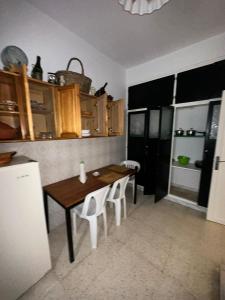 a kitchen with a wooden table and white chairs at Appartement henda 01 in Sousse