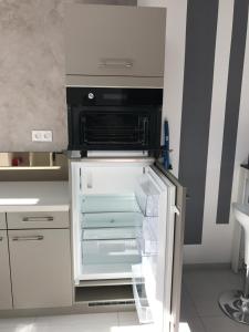 an empty refrigerator with its door open in a kitchen at Vanilla in Pierrelatte