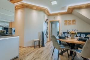 a kitchen and dining room with a wooden table and chairs at Apartament Między Górami in Kacwin