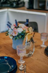 a table with a vase with a bouquet of flowers and glasses at Apartament Między Górami in Kacwin