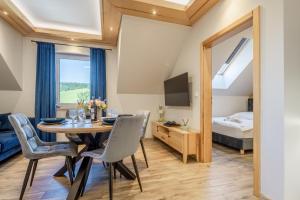 a dining room with a table and chairs and a bedroom at Apartament Między Górami in Kacwin +30 photos