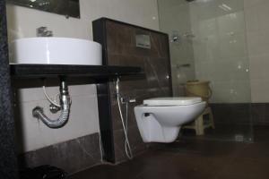 a bathroom with a toilet and a sink at The Lotus Boutique Hotel in Chikmagalūr