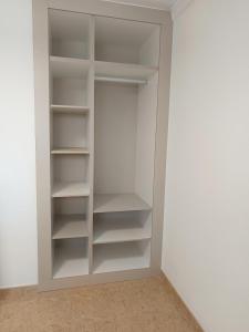 a closet with white shelves in a room at Teror Playa in Playa del Ingles