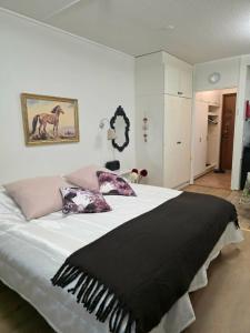 a bedroom with a large bed with a black blanket at Kylpylä-Hotelli 364 in Ikaalinen