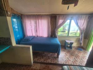 a bedroom with a blue bed and a window at Cabañas T Estefany in Bocas Town +10 photos