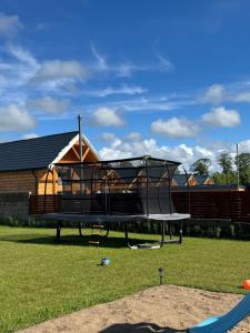 a tree house with a trampoline in a yard at Sunbella Sarbinowo in Sarbinowo
