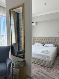 a bedroom with a mirror and a bed and a chair at Villa Marnero in Grigoleti