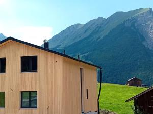 a wooden building with a mountain in the background at Appartment Waldtraum in Au im Bregenzerwald +4 photos