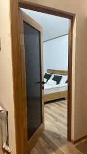 a glass door leading to a bedroom with a bed at Shenlik Cozy House in Chʼinchʼin