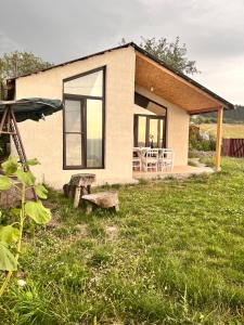 a small house with a bench in front of it at Shenlik Cozy House in Chʼinchʼin
