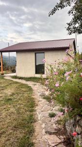 a building with a window and some pink flowers at Shenlik Cozy House in Chʼinchʼin +15 photos