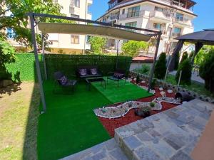 a backyard with green grass and a gazebo at Студио Морелия in Tsarevo