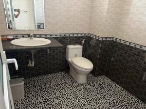 a bathroom with a toilet and a sink at G7 Hotel in Quyền Hoành +4 photos