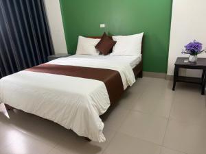 a large bed in a room with a green wall at G7 Hotel in Quyền Hoành
