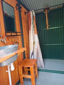 a bench and a chair in a room at Hideaway Glamping cabin- Caban cudd in Criccieth