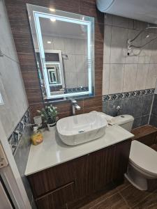 a bathroom with a sink and a toilet and a mirror at Стаи под наем Иви - Равда in Ravda +82 photos
