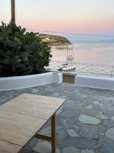 a wooden bench sitting on top of a patio with the ocean at Salt & Sun Terrace Seafront in Agioi Apostoli