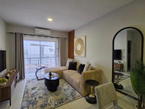 a living room with a couch and a large window at Galani Homes Comfort 2-Bed Suite in Gaborone