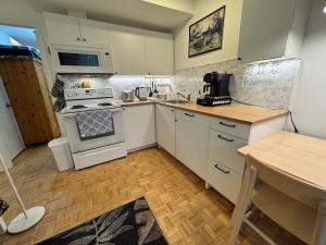 a kitchen with white cabinets and a stove top oven at Montreal Hideaway in a Residential area in Montreal