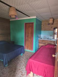 a bedroom with a bed and a green wall at Cabañas T Estefany in Bocas Town